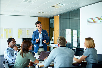 Buy stock photo Shot of a man giving a presentation to coworkers in an office