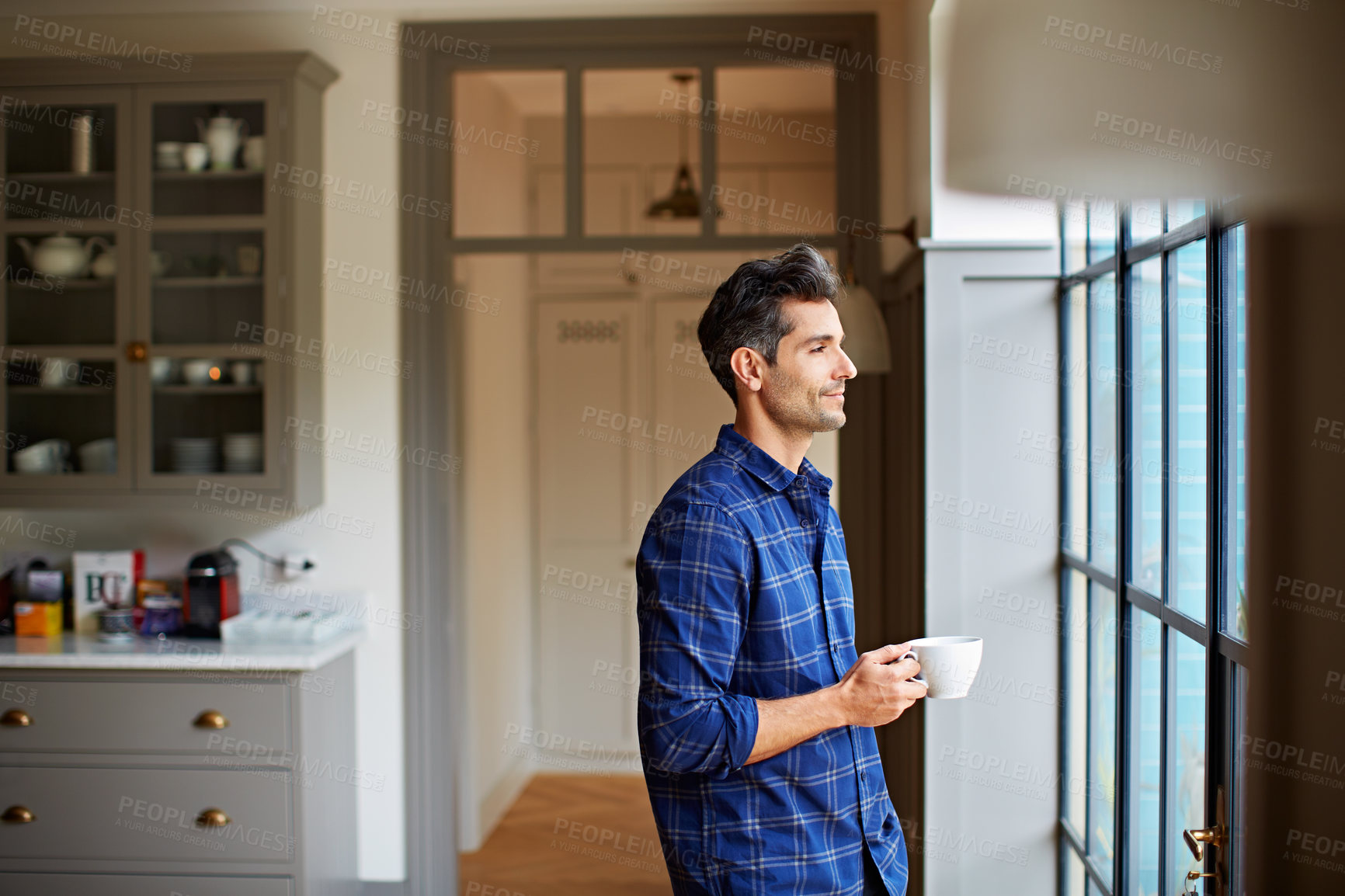Buy stock photo Thinking, smile and man at window with coffee, daydreaming and calm mindset on weekend break. Reflection, happy and person in house with warm drink, inspiration and peaceful perspective on day off.