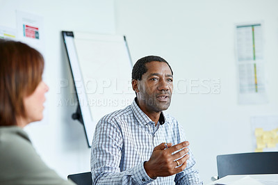 Buy stock photo Shot of two colleagues talking together in a modern office