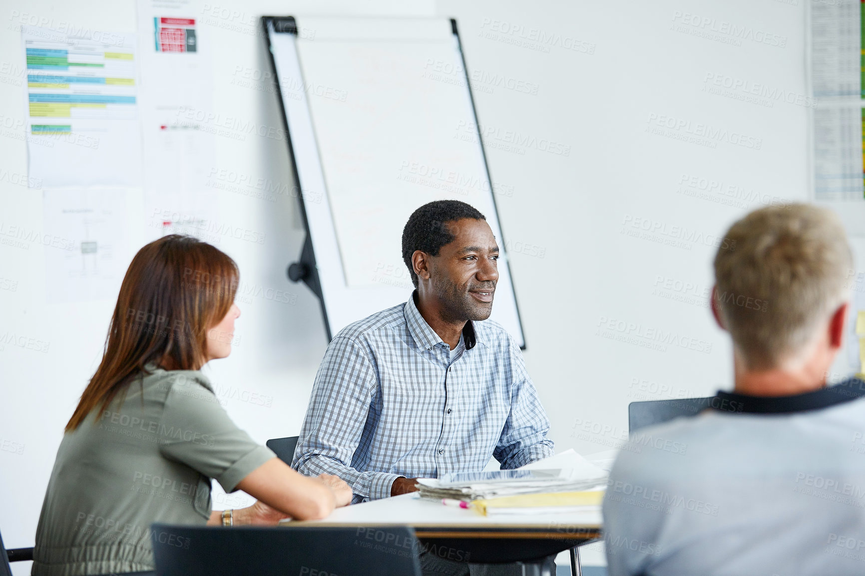 Buy stock photo Shot of a group of colleagues talking together in a modern office
