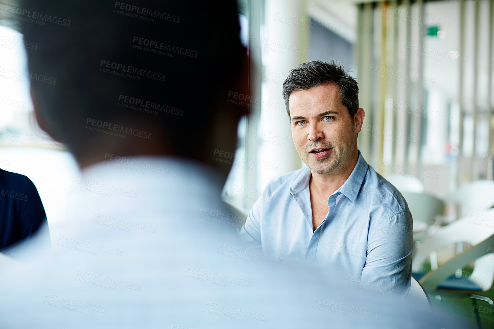 Buy stock photo Shot of two coworkers talking together while sitting in an office