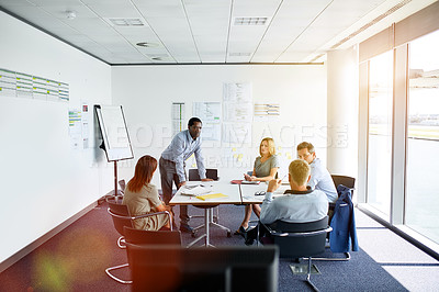 Buy stock photo Shot of colleagues having a meeting around a boardroom table in an office