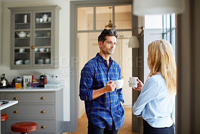 Buy stock photo Shot of a young couple drinking coffee together in their kitchen
