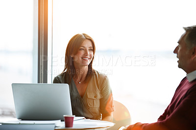 Buy stock photo Shot of two coworkers talking together while sitting in an office