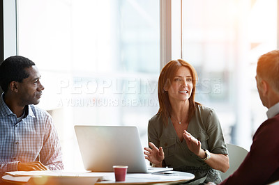Buy stock photo Shot of three professional businesspeople meeting in their office