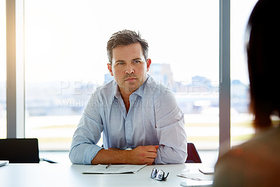 Buy stock photo Shot of a mature businessman sitting in the boardroom during a meeting