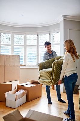 Buy stock photo Shot of a happy young couple moving furniture in their new house