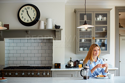 Buy stock photo Shot of a young woman having breakfast at home