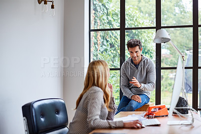 Buy stock photo Shot of a young couple working together in their home office