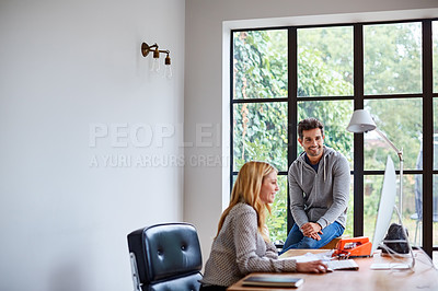 Buy stock photo Shot of a young couple working together in their home office