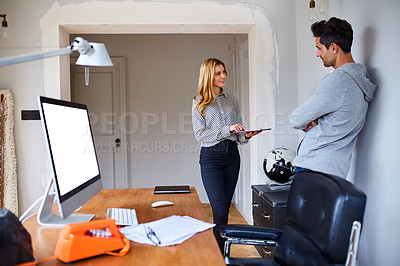Buy stock photo Shot of a young couple working together in their home office