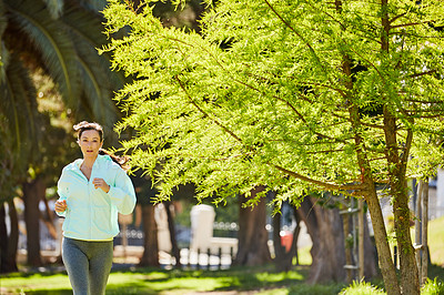 Buy stock photo Cropped portrait of an attractive and athletic young sportswoman out for a jog in the park
