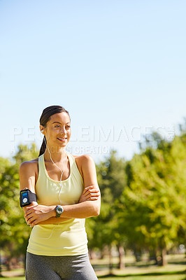 Buy stock photo Cropped shot of an attractive and athletic young sportswoman listening to music while out for a jog in the park