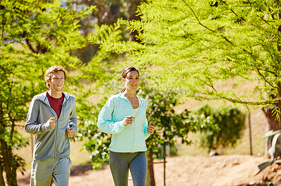 Buy stock photo Cropped shot of an affectionate and athletic young couple out for a jog in the park