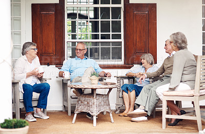Buy stock photo Full length shot of a group of senior citizens sitting together and enjoying a day out on the veranda