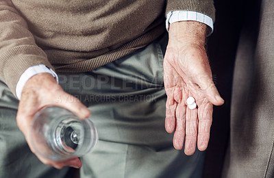 Buy stock photo Cropped shot of a senior man taking his medication with a glass of water