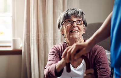 Buy stock photo Shot of a nurse caring for a senior woman with a walking stick at home