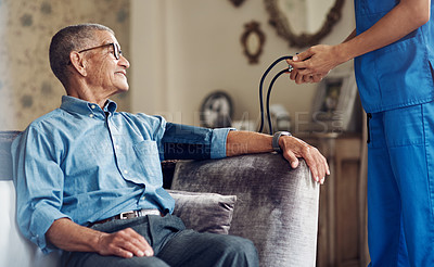 Buy stock photo Shot of a senior man getting his blood pressure measured during a checkup with a nurse at home