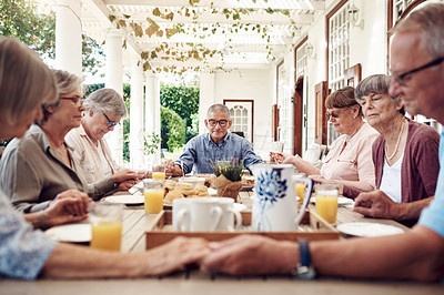 Buy stock photo Cropped shot of a group of senior citizens sitting together and holding hands to pray before enjoying their tea party