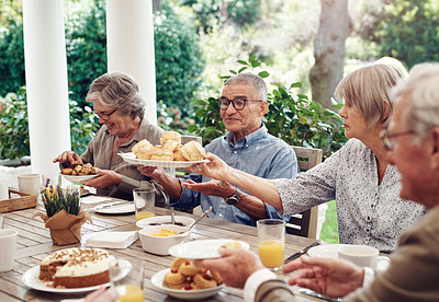 Buy stock photo Cropped shot of a group of senior citizens sitting together and enjoying a tea party outdoors