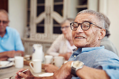 Buy stock photo Cropped portrait of a happy senior man sitting and enjoying a tea party with his friends outdoors