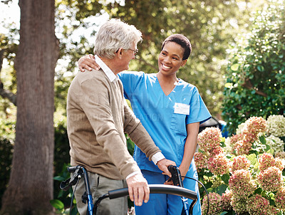 Buy stock photo Cropped shot of an attractive young nurse helping her senior patient walk with his walker during a day outdoors