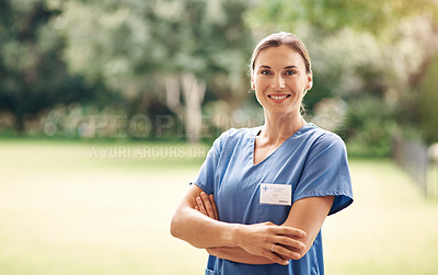 Buy stock photo Portrait of a confident young nurse standing outside in the garden of a retirement home