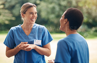 Buy stock photo Shot of two young nurses talking outside in the garden of a retirement home
