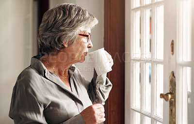 Buy stock photo Shot of a senior woman having coffee and looking thoughtfully out of a window
