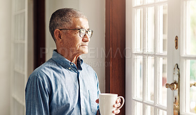 Buy stock photo Shot of a senior man having coffee and looking thoughtfully out of a window