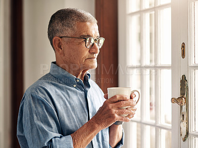 Buy stock photo Shot of a senior man having coffee and looking thoughtfully out of a window