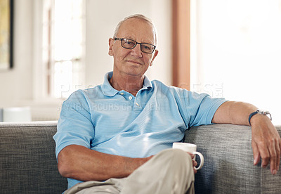Buy stock photo Shot of a senior man having a coffee break on the sofa at home