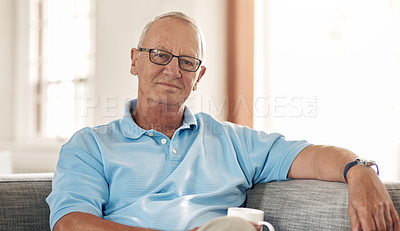 Buy stock photo Shot of a senior man having a coffee break on the sofa at home