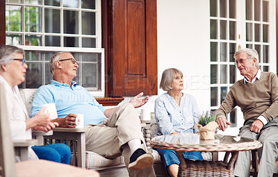 Buy stock photo Cropped shot of a group of senior citizens sitting together and enjoying a day out on the veranda