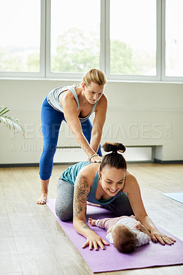 Buy stock photo Full length shot of an attractive young mother posing with her baby during a baby yoga class indoors