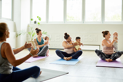 Buy stock photo Cropped shot of a young group of mothers sitting with their babies during a baby yoga class indoors