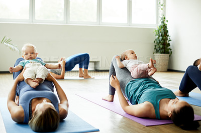 Buy stock photo Cropped shot of a young group of mothers lying down and posing with her babies during a baby yoga class