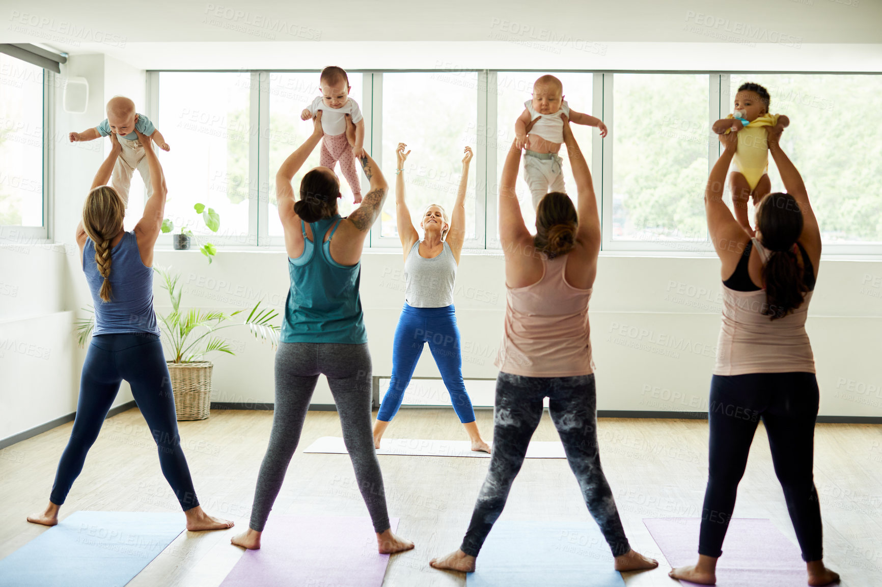 Buy stock photo Cropped shot of a group of mothers holding their babies during a baby yoga class indoors