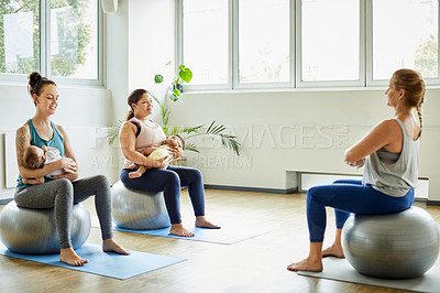 Buy stock photo Full length shot of two attractive young mothers sitting with their babies during a baby yoga class indoors