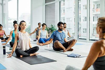 Buy stock photo Shot of a group of men and women meditating during a yoga class