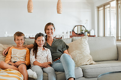 Buy stock photo Shot of a young boy and girl sitting at home with their mother