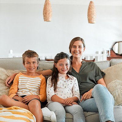 Buy stock photo Shot of a young boy and girl sitting at home with their mother