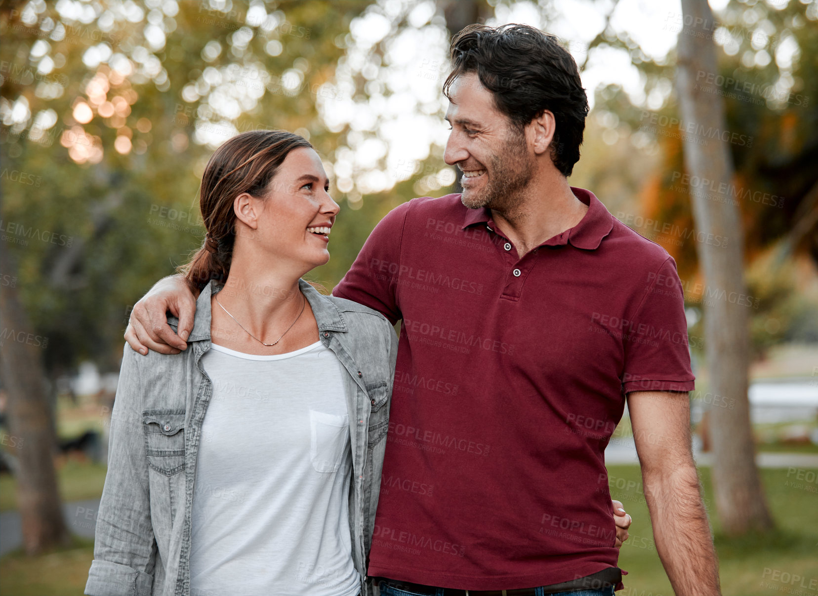 Buy stock photo Cropped shot of an affectionate couple taking a walk through the park