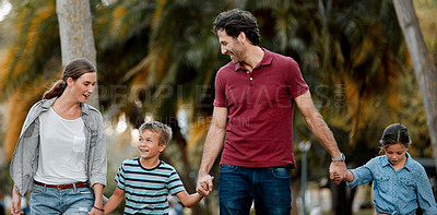 Buy stock photo Shot of a couple with two kids taking a walk through the park together