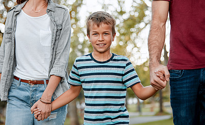 Buy stock photo Shot of a young boy out for a walk through the park with his parents