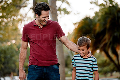Buy stock photo Shot of a man and his son taking a walk through the park