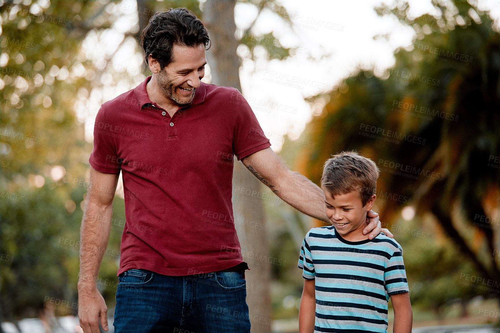 Buy stock photo Shot of a man and his son taking a walk through the park