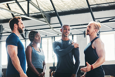Buy stock photo Cropped shot of a group of young athletes talking while standing in the gym