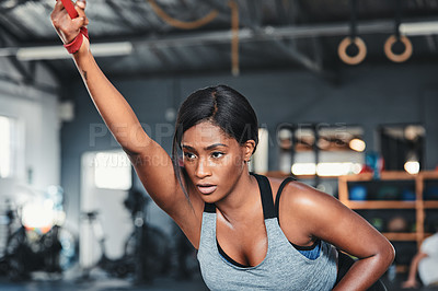 Buy stock photo Cropped shot of an attractive young female athlete working out with a resistant band in the gym
