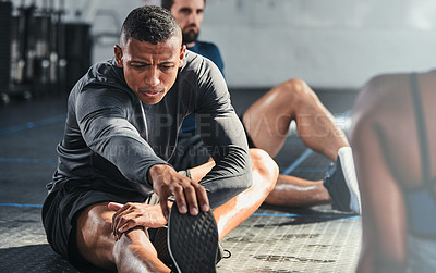 Buy stock photo Cropped shot of a group of young athletes going through their warmup routine in the gym